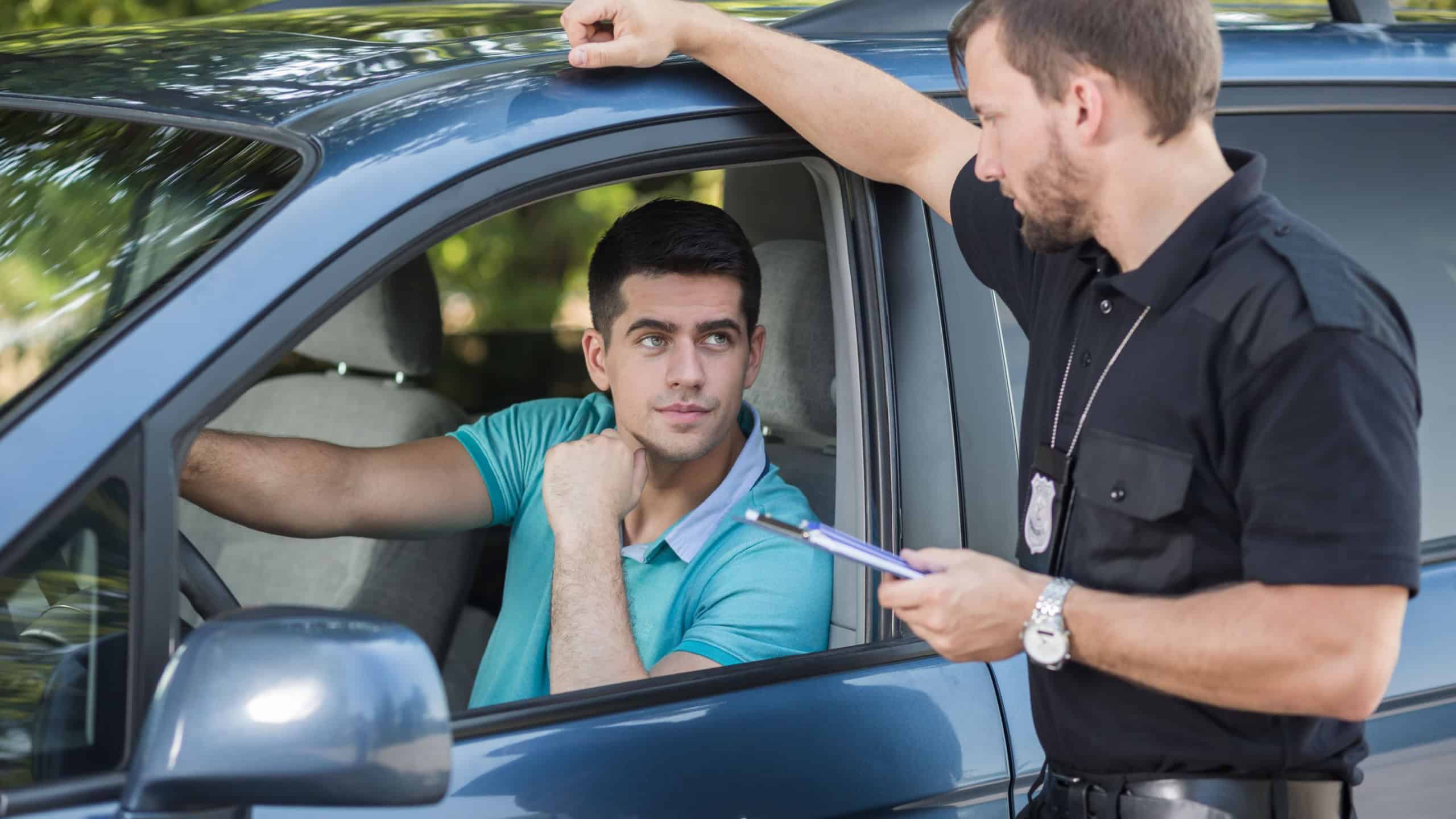 Shot of a young driver talking to a traffic policeman