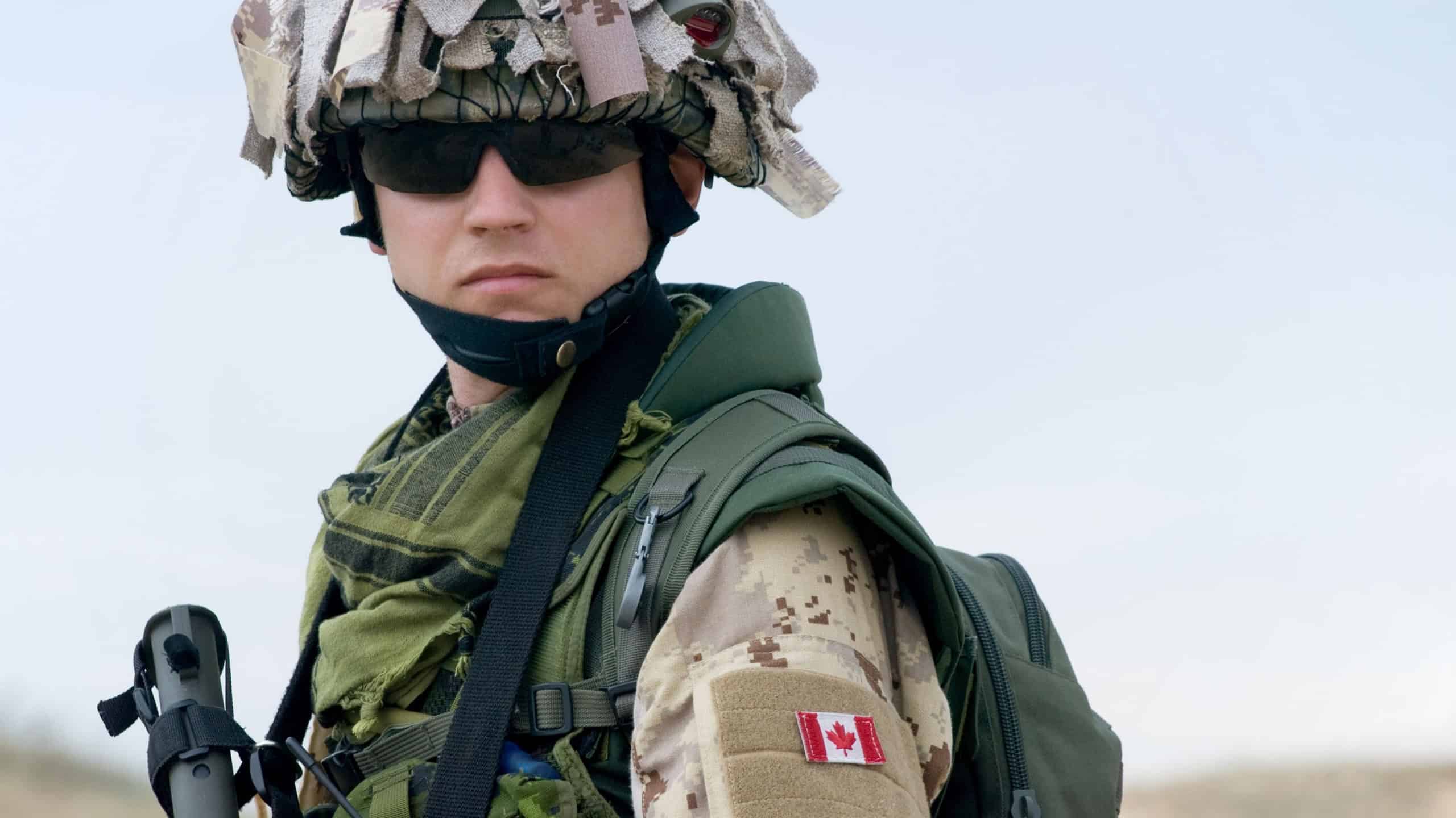 Canadian soldier in desert uniform holding his rifle