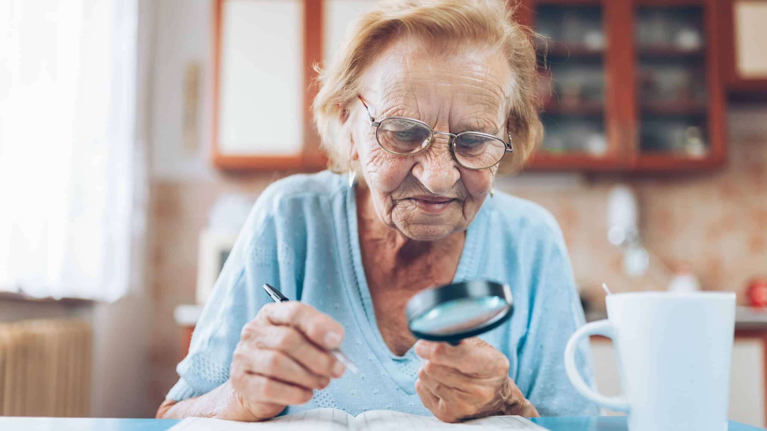 Senior woman in her 80s enjoys solving a crossword puzzle