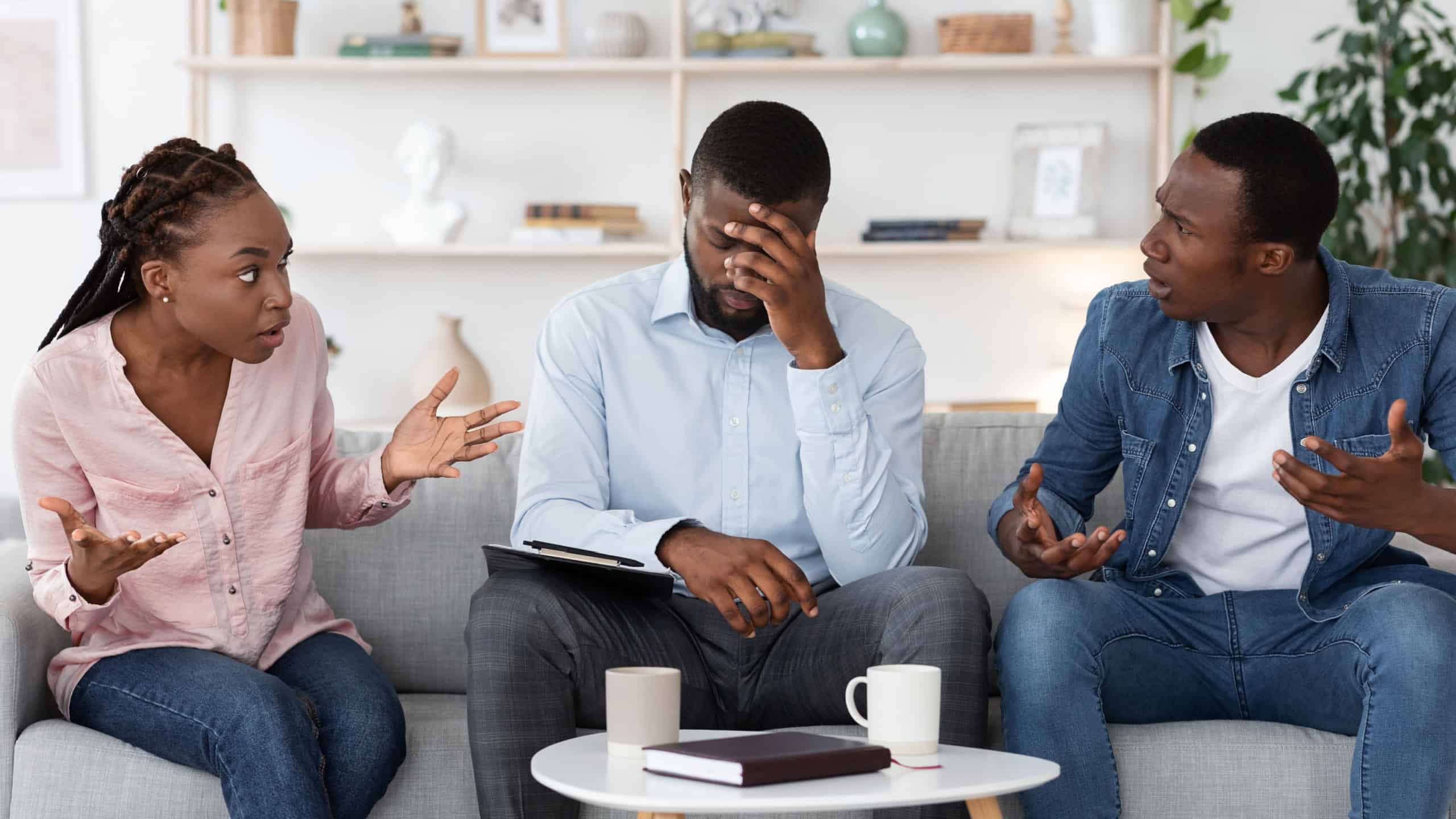 Desperate Family Counselor Sitting On Couch Between Arguing Couple At His Office, Tired Of Their Arguing, Free Space