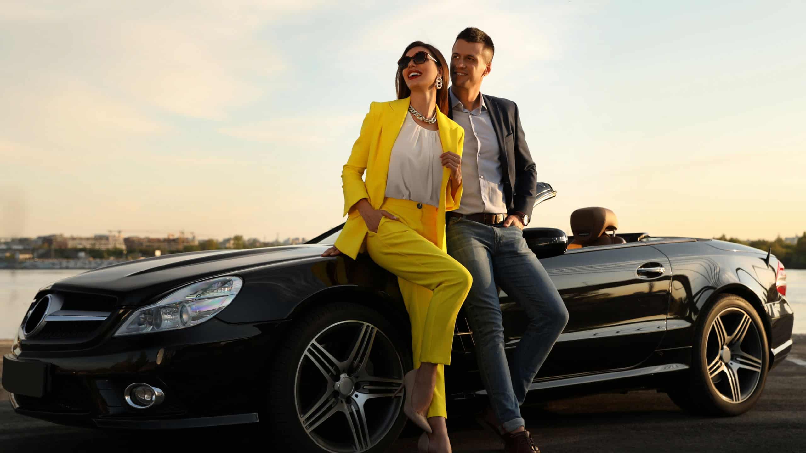 Stylish couple near luxury convertible car outdoors