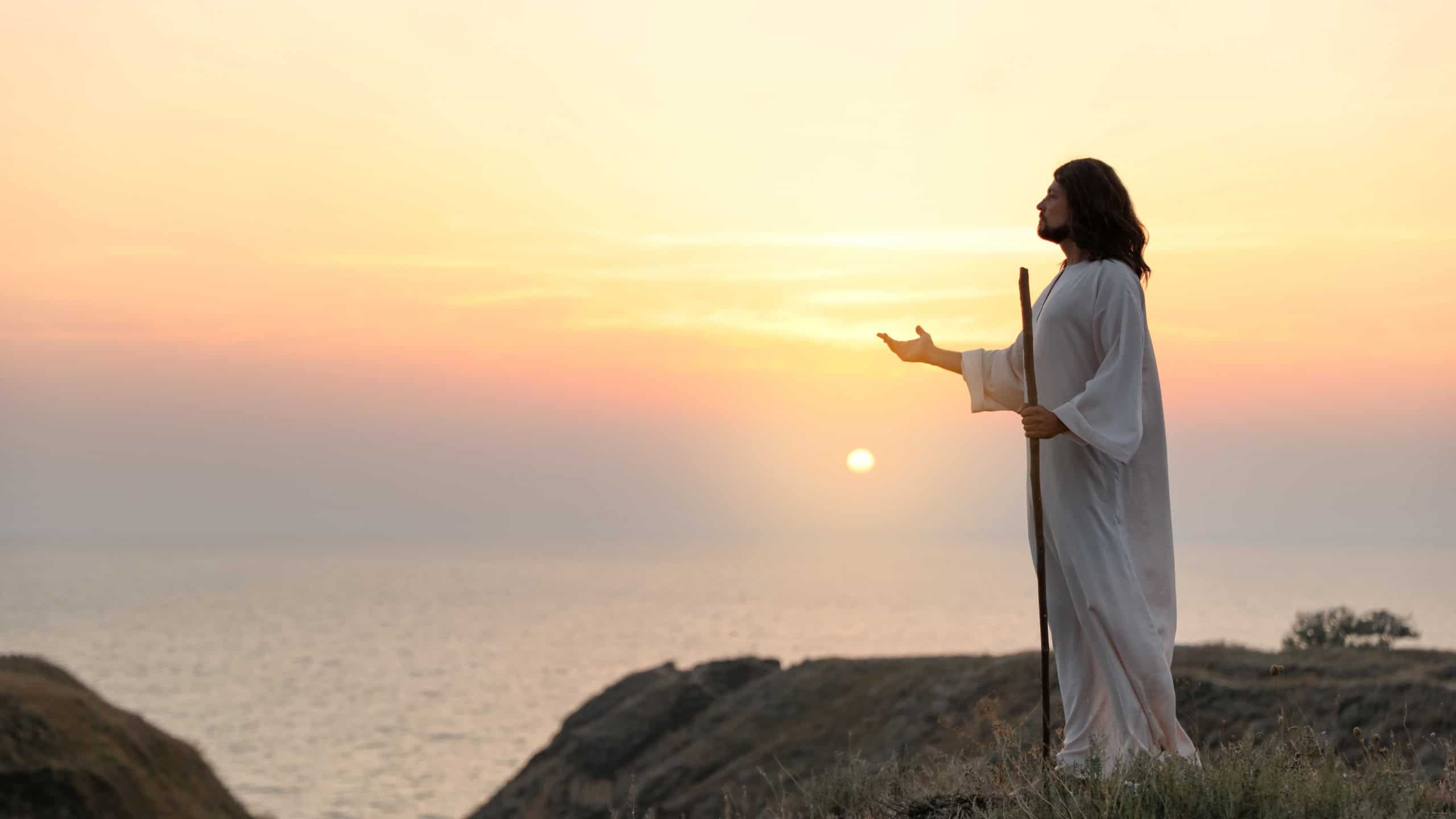 Jesus Christ on hills at sunset. Space for text