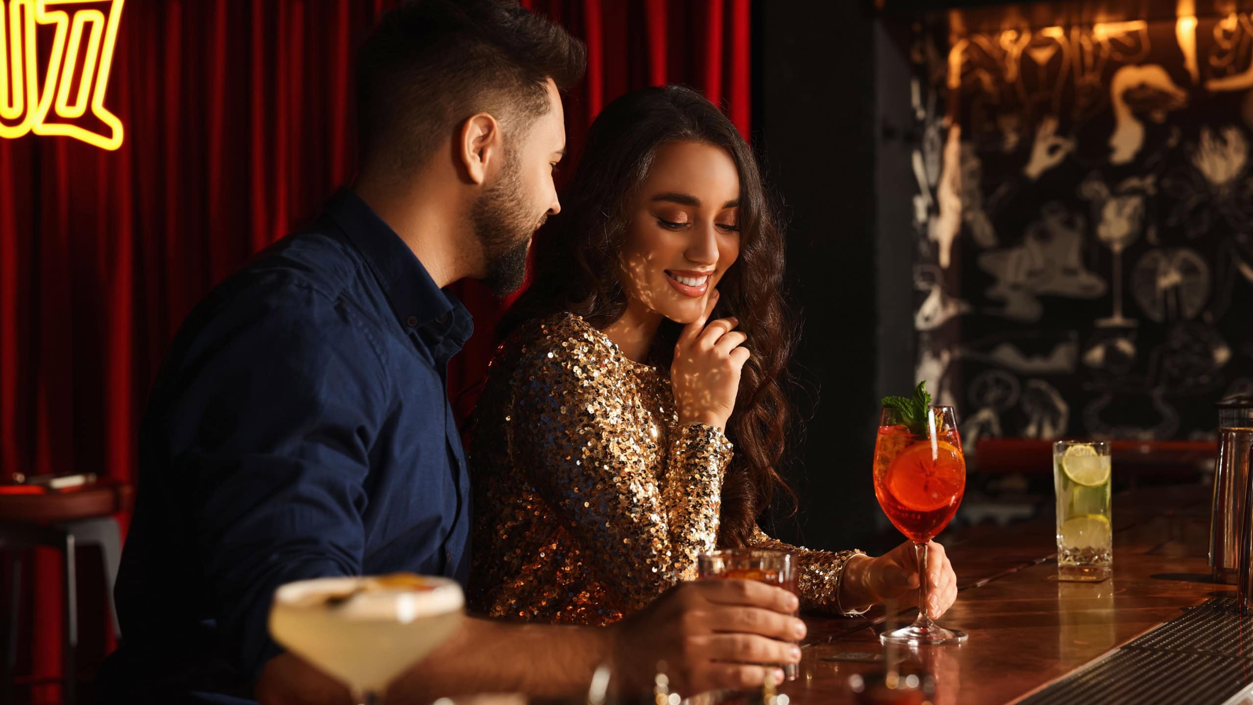 Lovely couple with fresh cocktails at bar counter