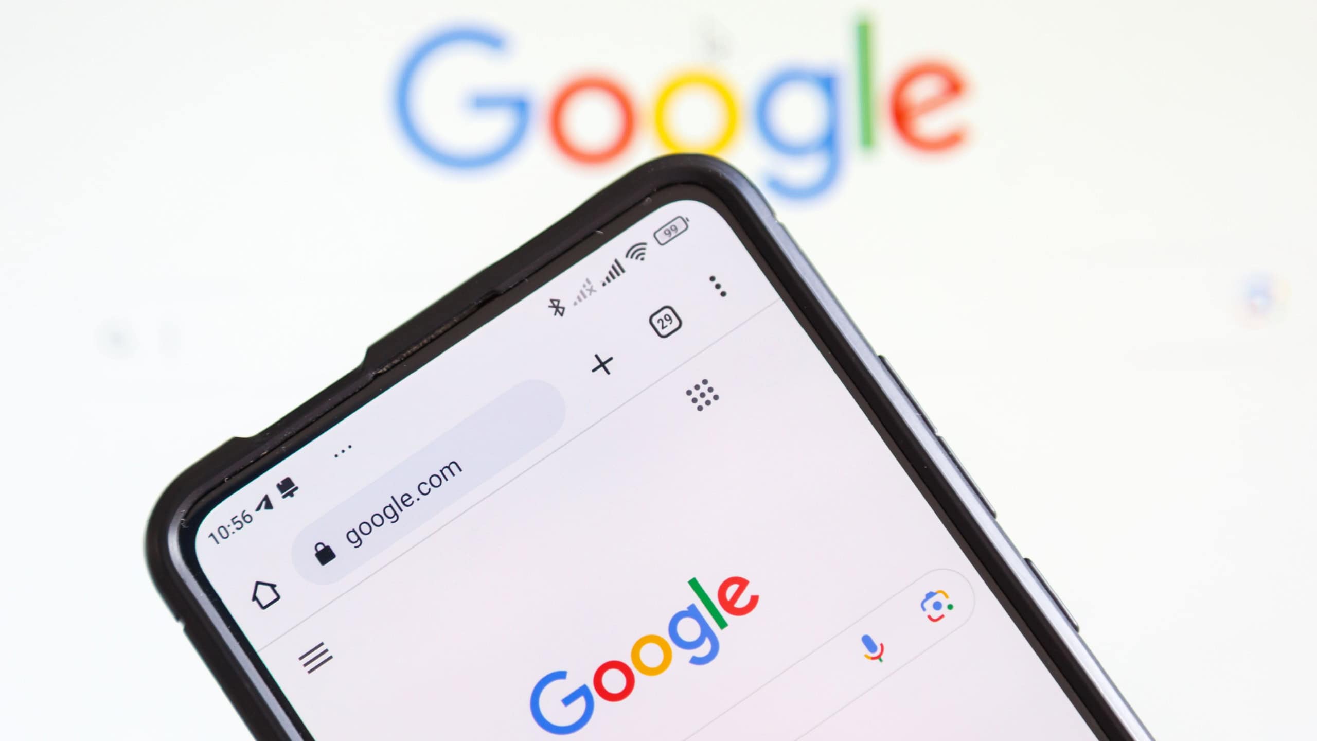 Google logo of the computer hardware software manufacturer on a mobile phone and screen in Stuttgart, Germany.