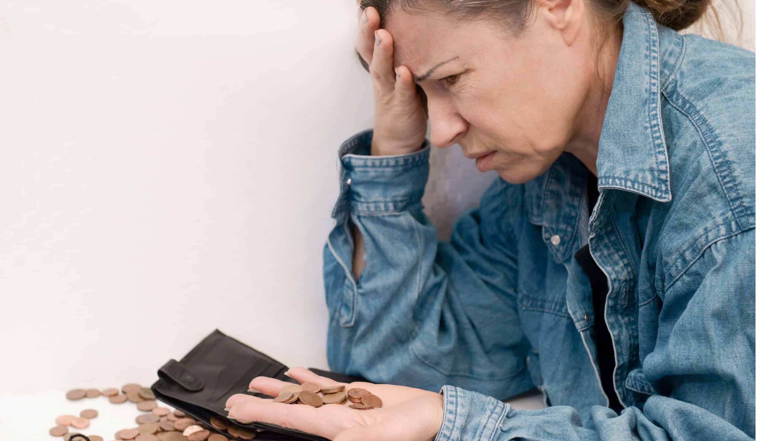 an elderly woman in old age with emotions of stress holds small euro coins in her palm next to a mountain of the same coins with a wallet,a piggy bank bag.concept of poverty,money crisis,small pension