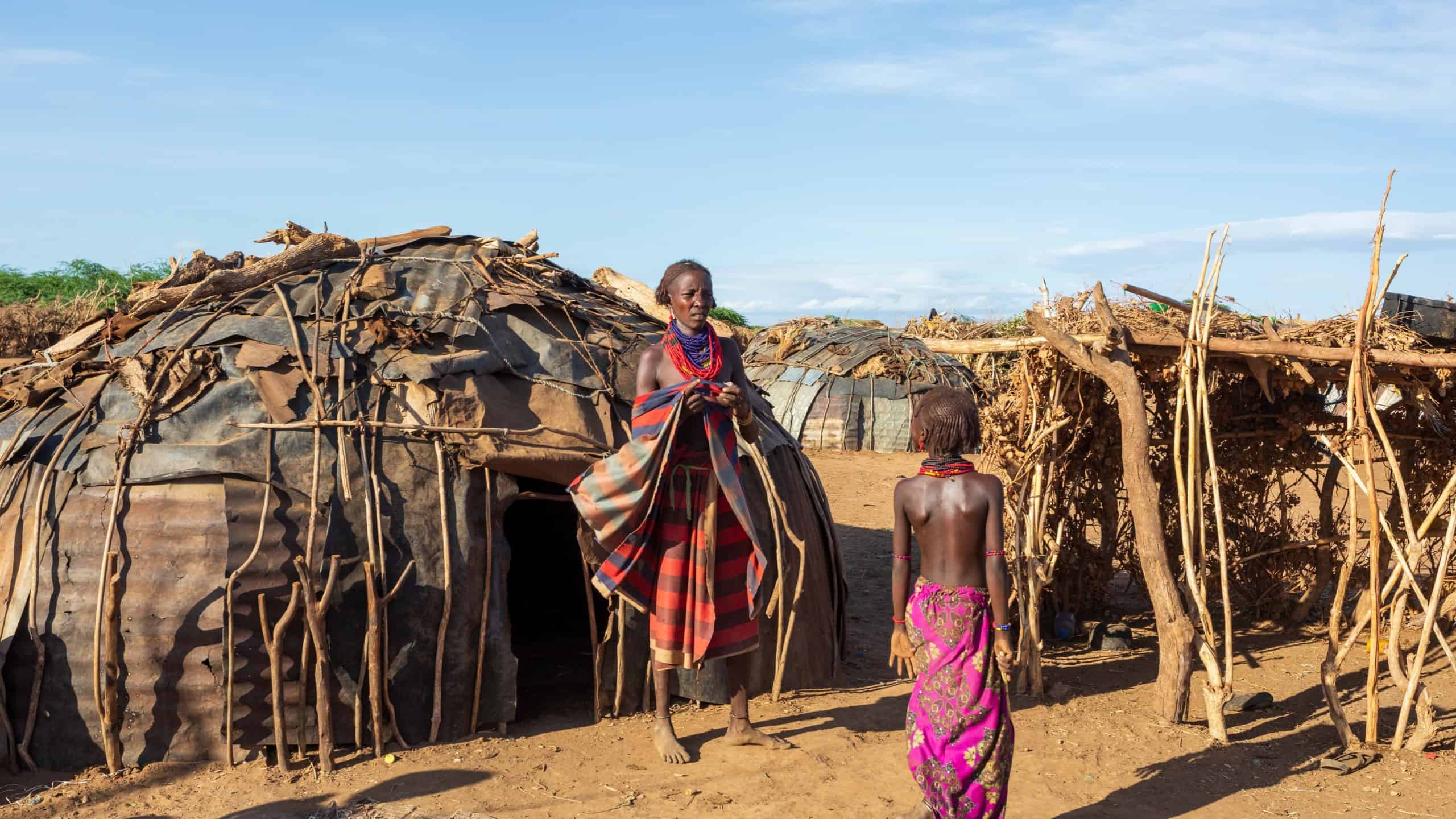 Omorate, Omo Valley, Ethiopia - May 11, 2019: Woman from the African tribe Dasanesh in front of traditional hut. Daasanach are Cushitic ethnic group inhabiting in Ethiopia, Kenya, and South Sudan