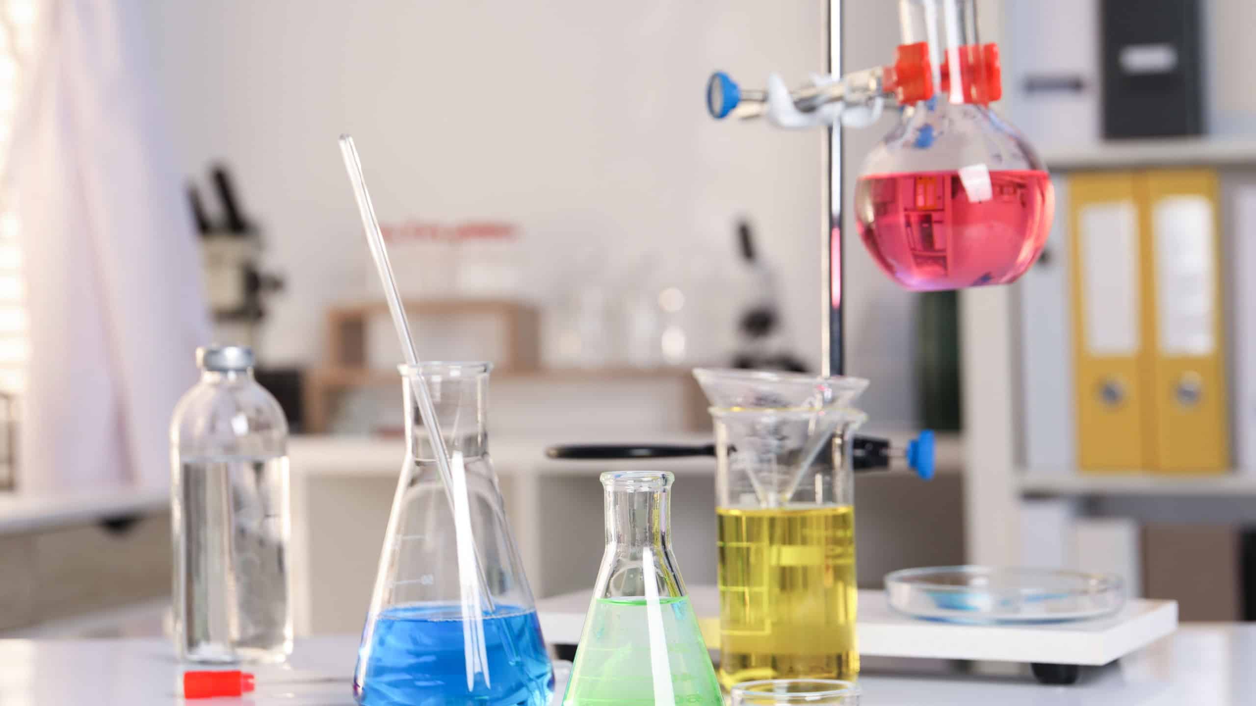 Laboratory analysis. Glassware with different liquids on white table indoors