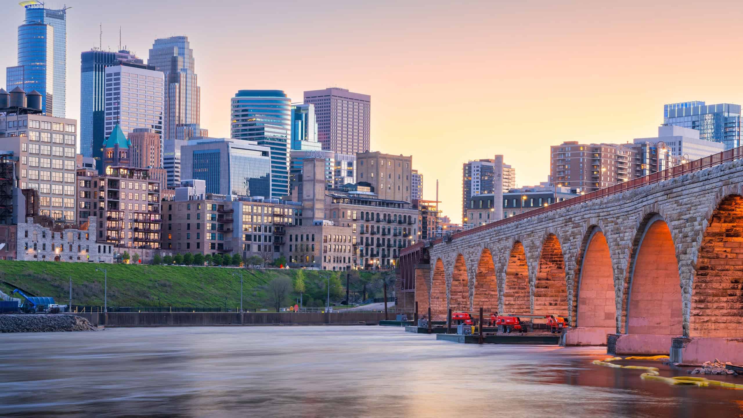 Minneapolis, Minnesota, USA skyline with the Stone Arch Bridge on the Mississippi River at dusk.