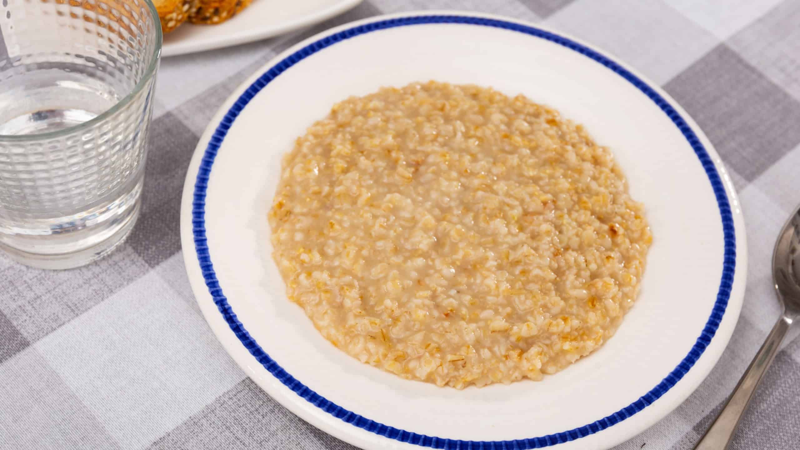 Appetizing milk oatmeal porridge served on plate for breakfast