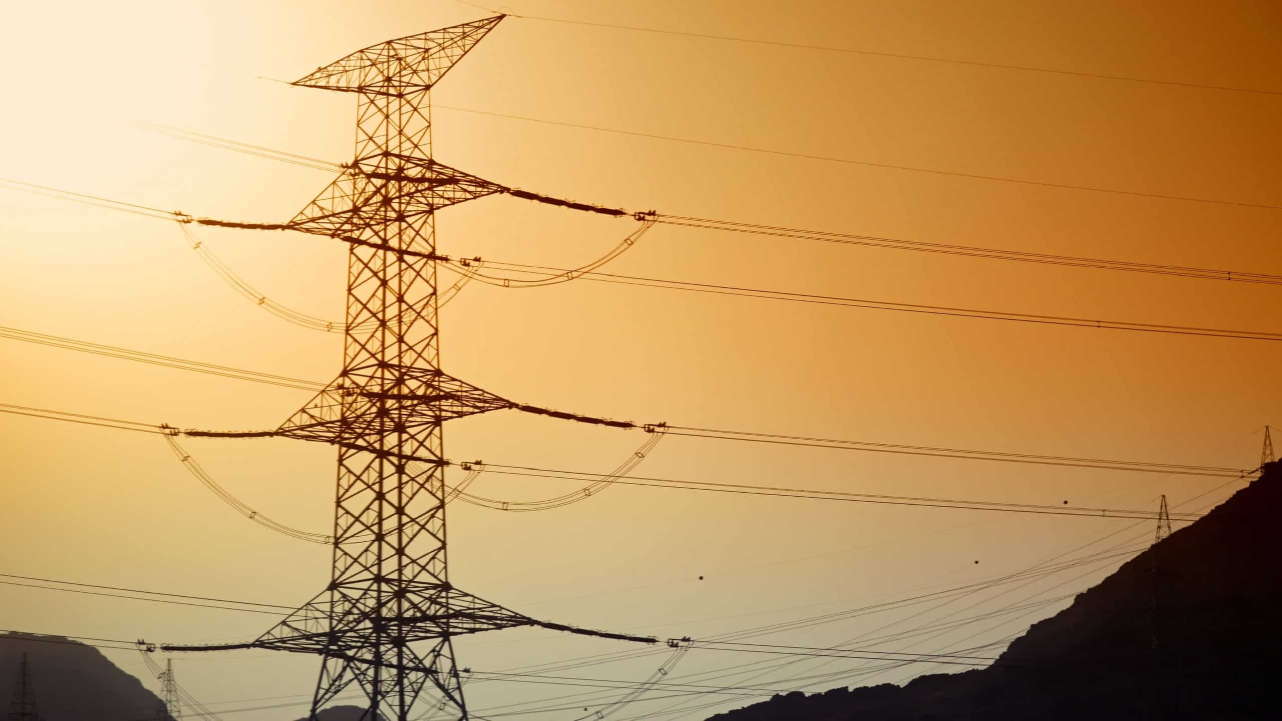 Power lines against a warm gradient sky. Ideal for conveying energy, infrastructure, and modern technology concepts. location in the city of Medina, Saudi Arabia