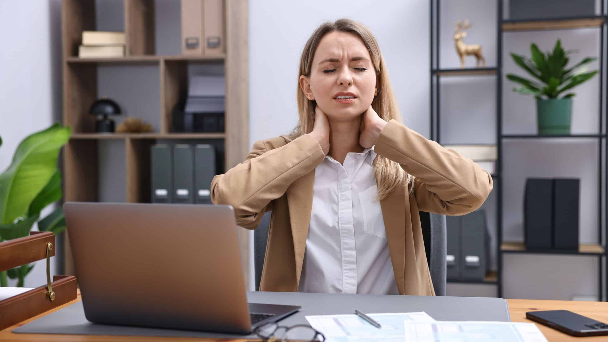 Woman feeling fatigue at wooden desk in office