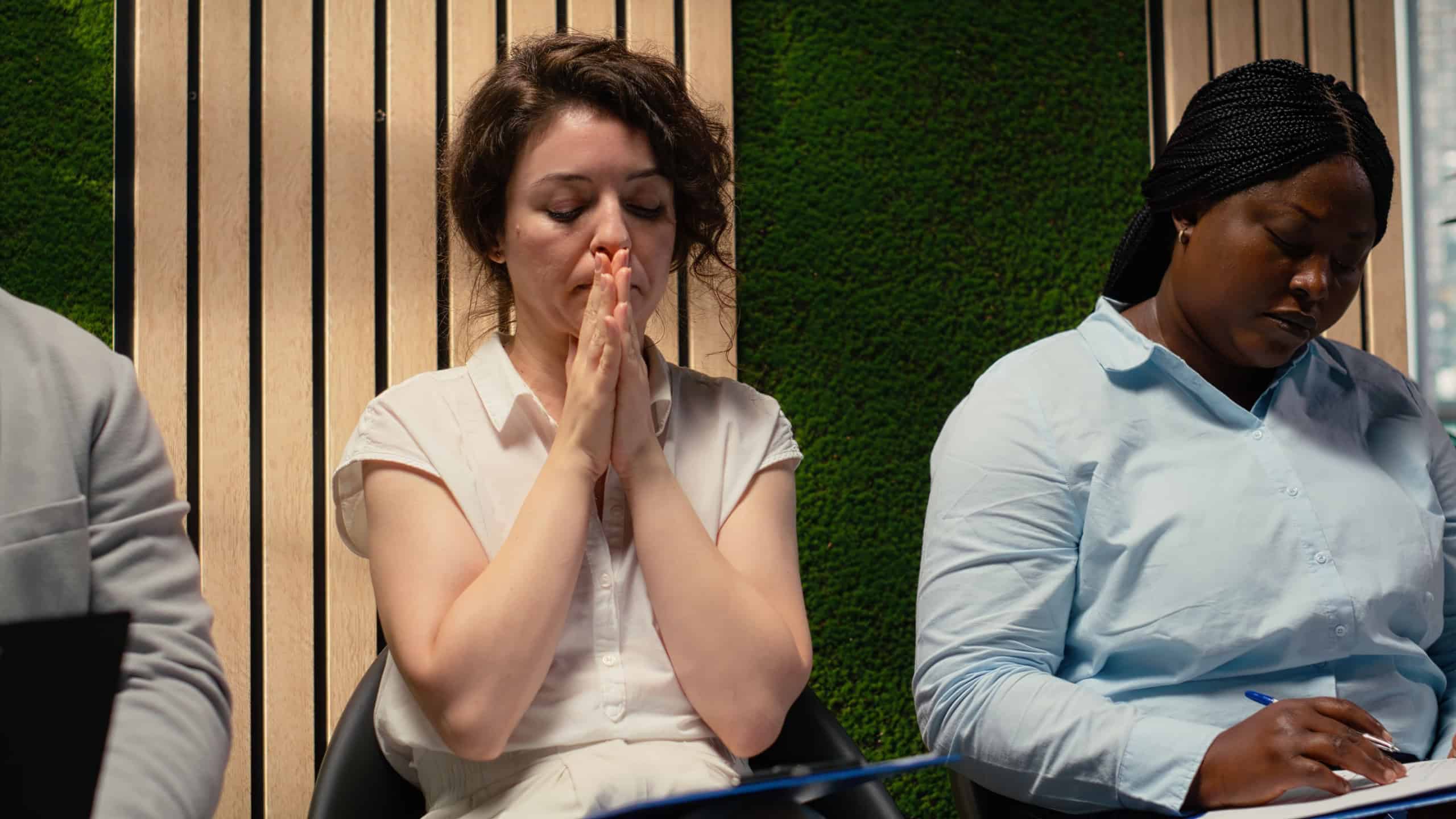 Scared impatient woman applicant getting extremely nervous and agitated while she waits in the queue outside HR office. Person sitting in line under pressure, deals with anxiety.
