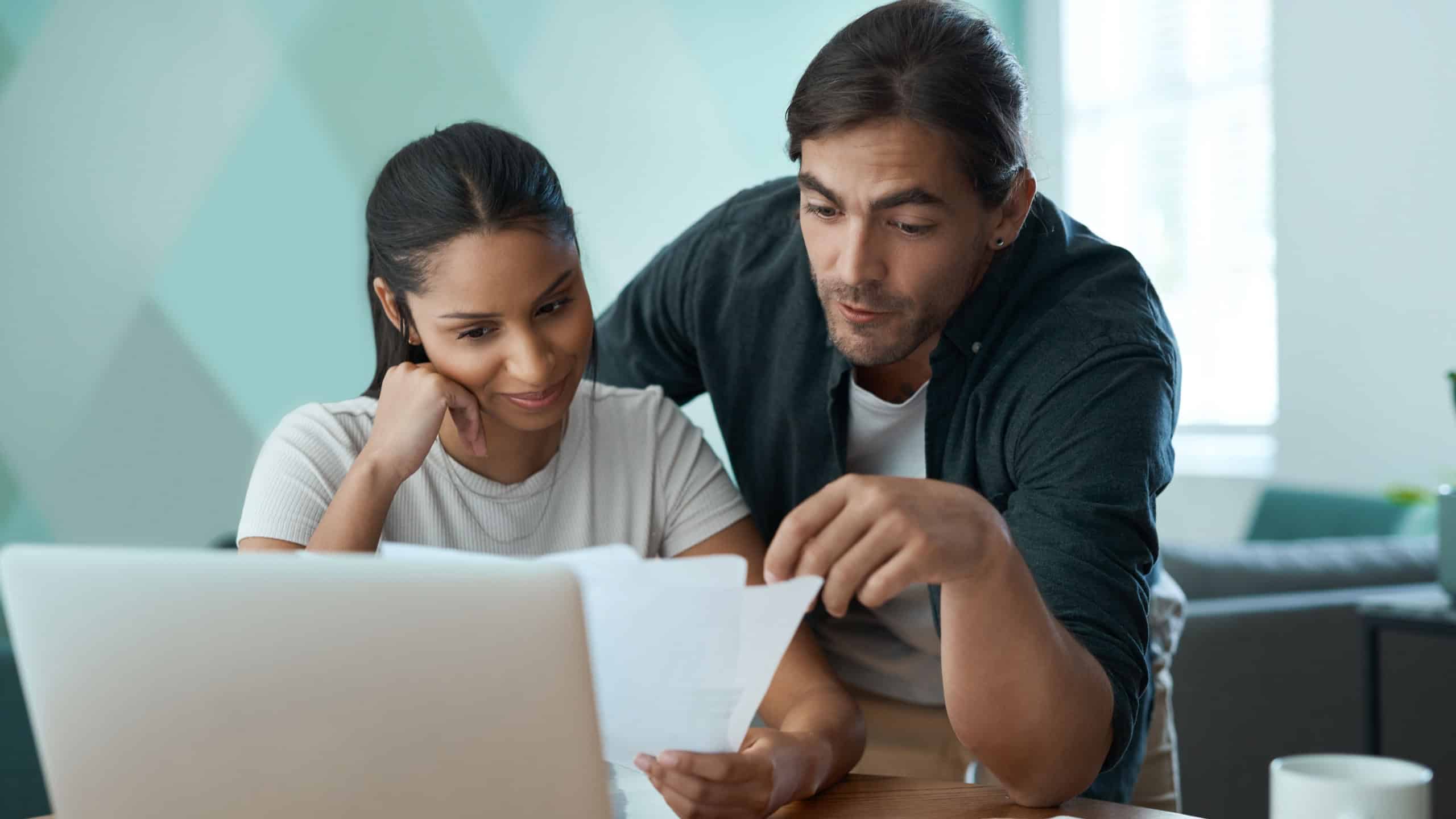 Reading, paperwork or couple with laptop in lounge, credit score research or home loan options discussion. Mortgage application, salary slip or people with pc for online banking app, talking or info