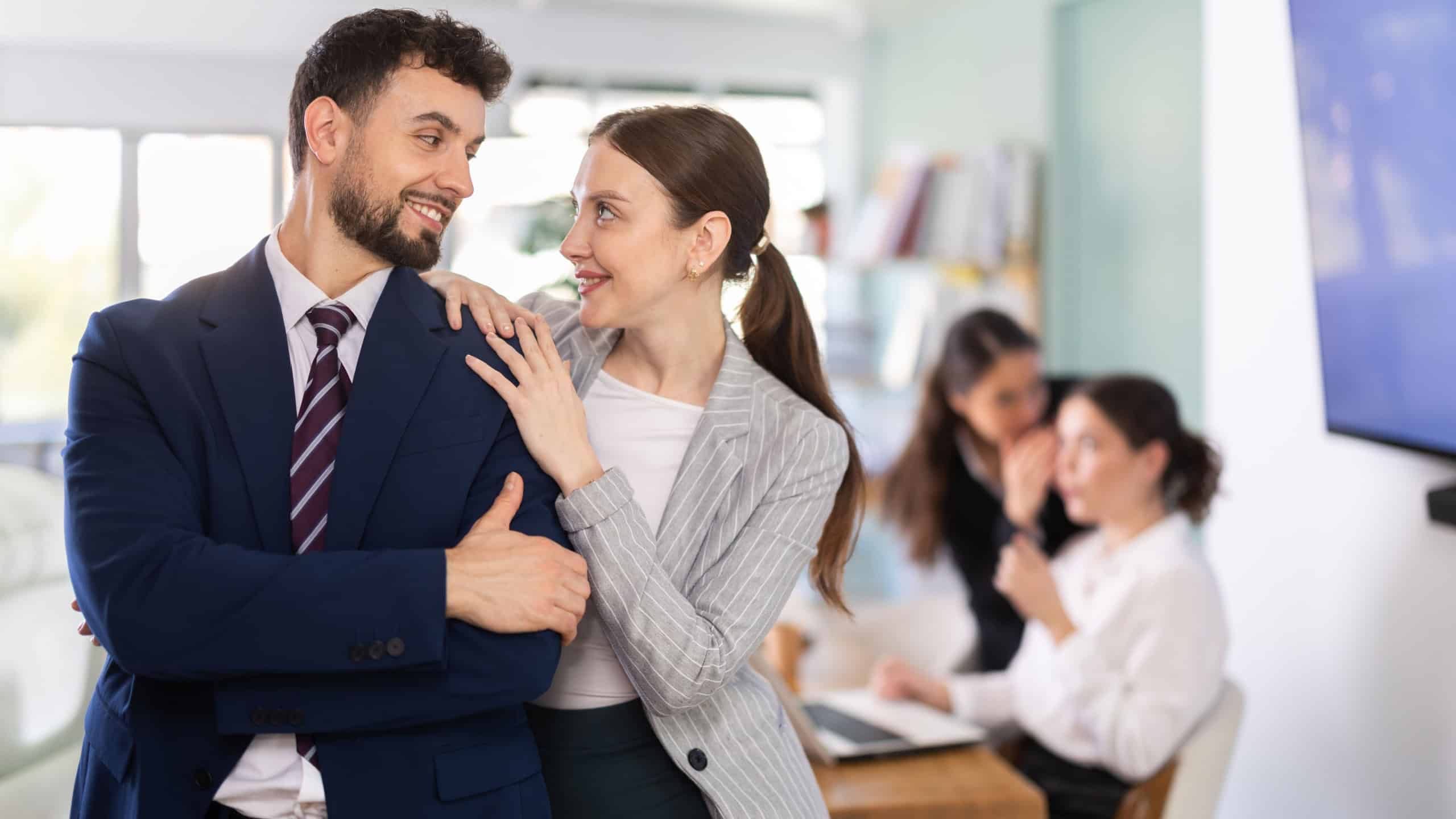 Young woman flirting with her male colleague with playful smile