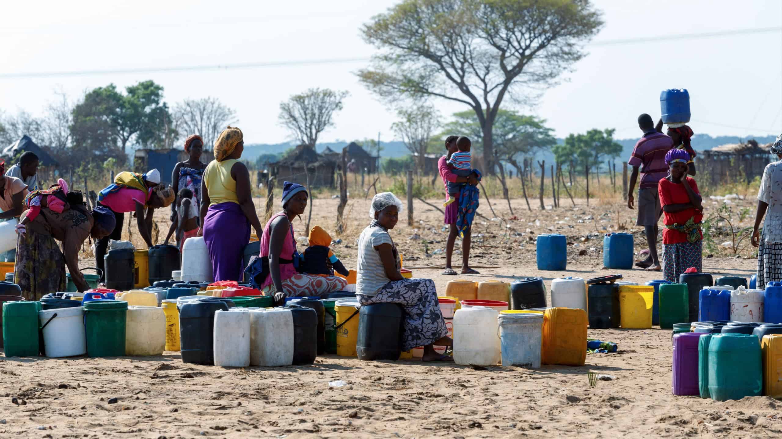 Unidentified Namibian woman with child near public tank with drinking water.Kavango region. October 15, 2014, Namibia