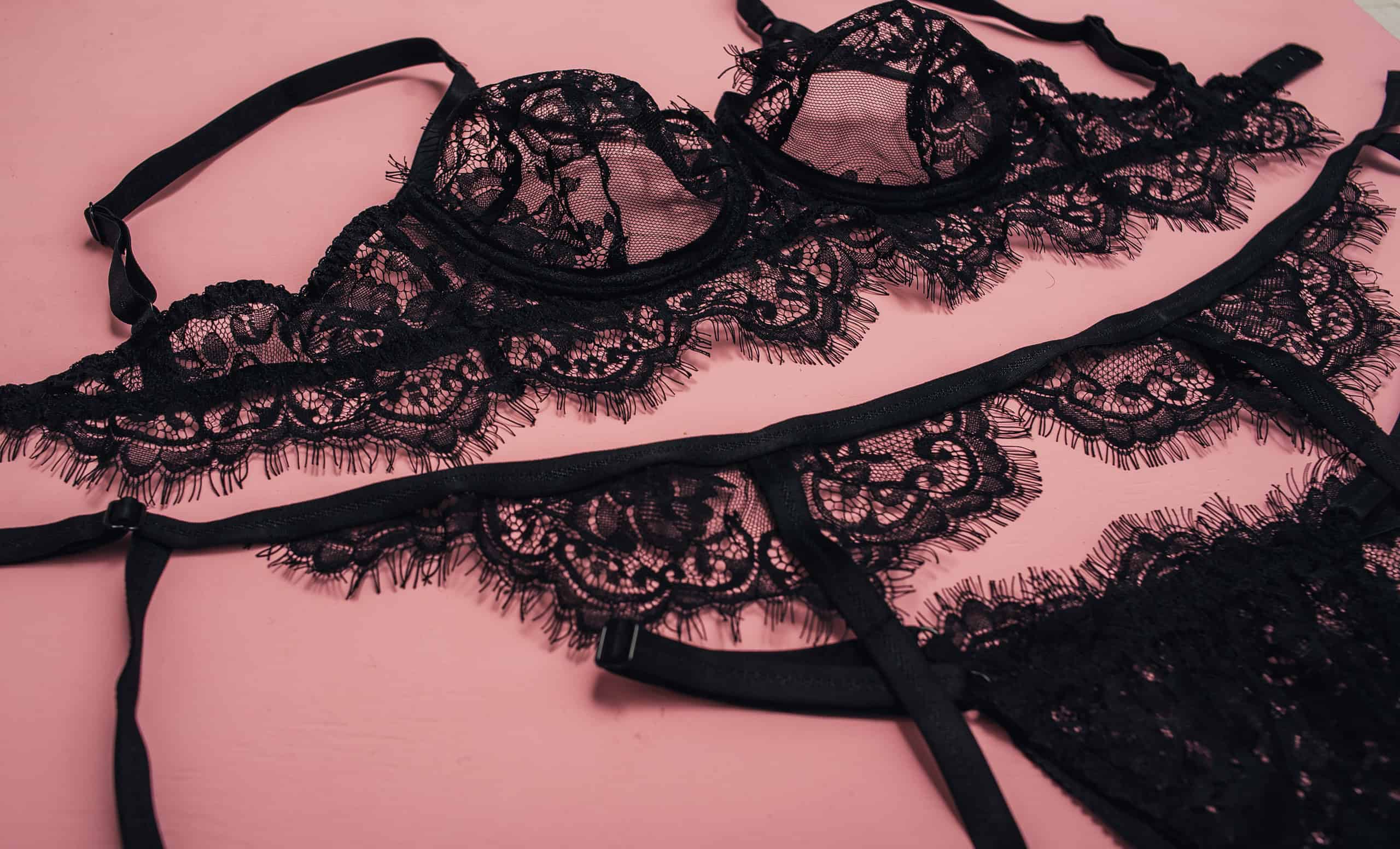 Woman's sexual red lingerie on white bedsheets from above. Copy space. Beauty, fashion blogger concept