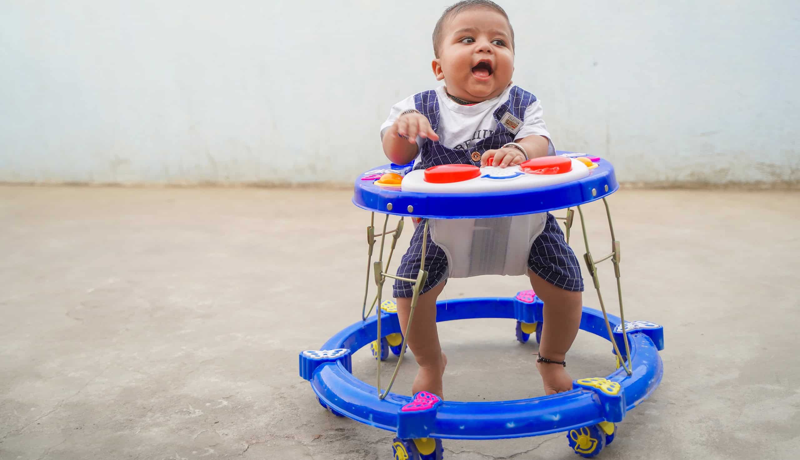 Cheerful Indian child in the baby walker.
