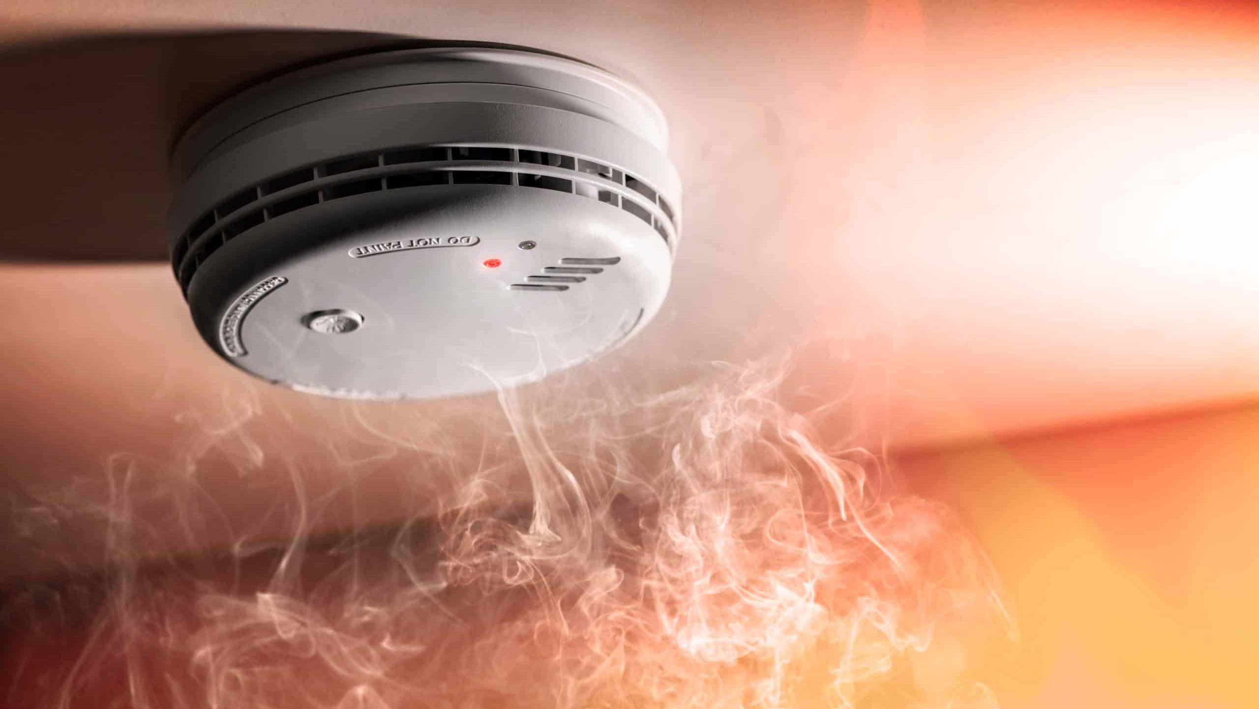 Smoke detector and interlinked fire alarm in action background with copy space