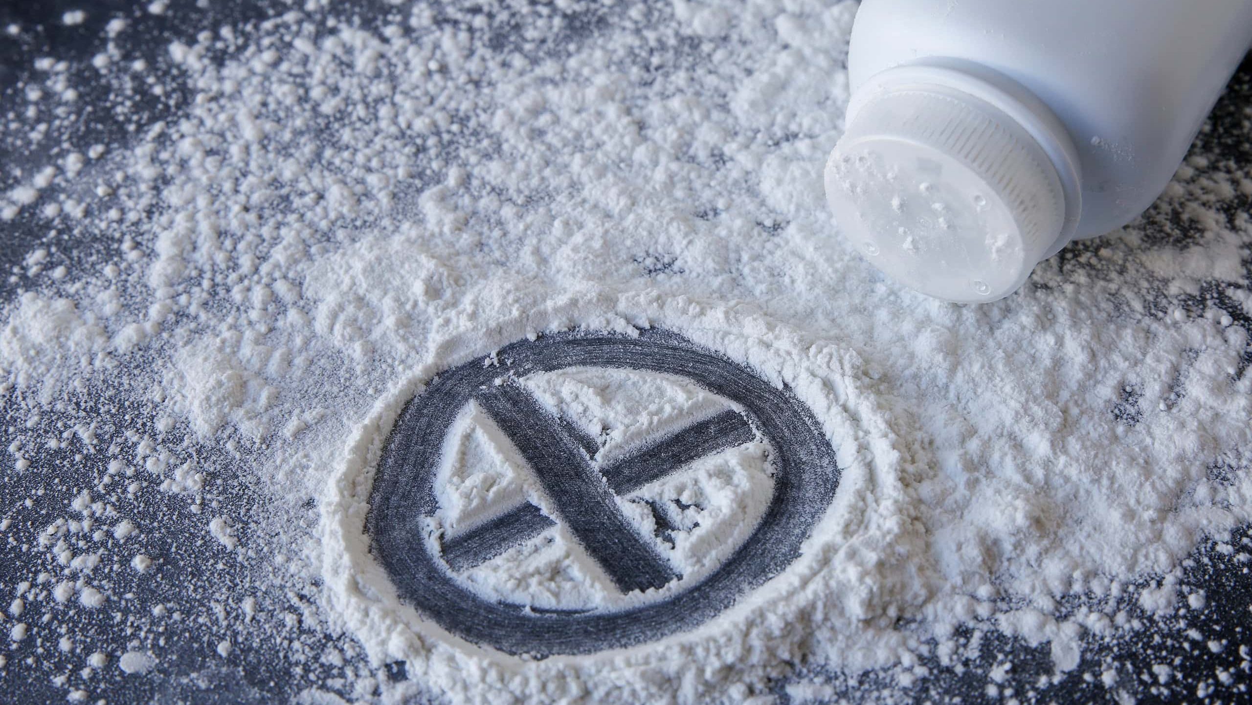 Talcum powder with cross sign on black background