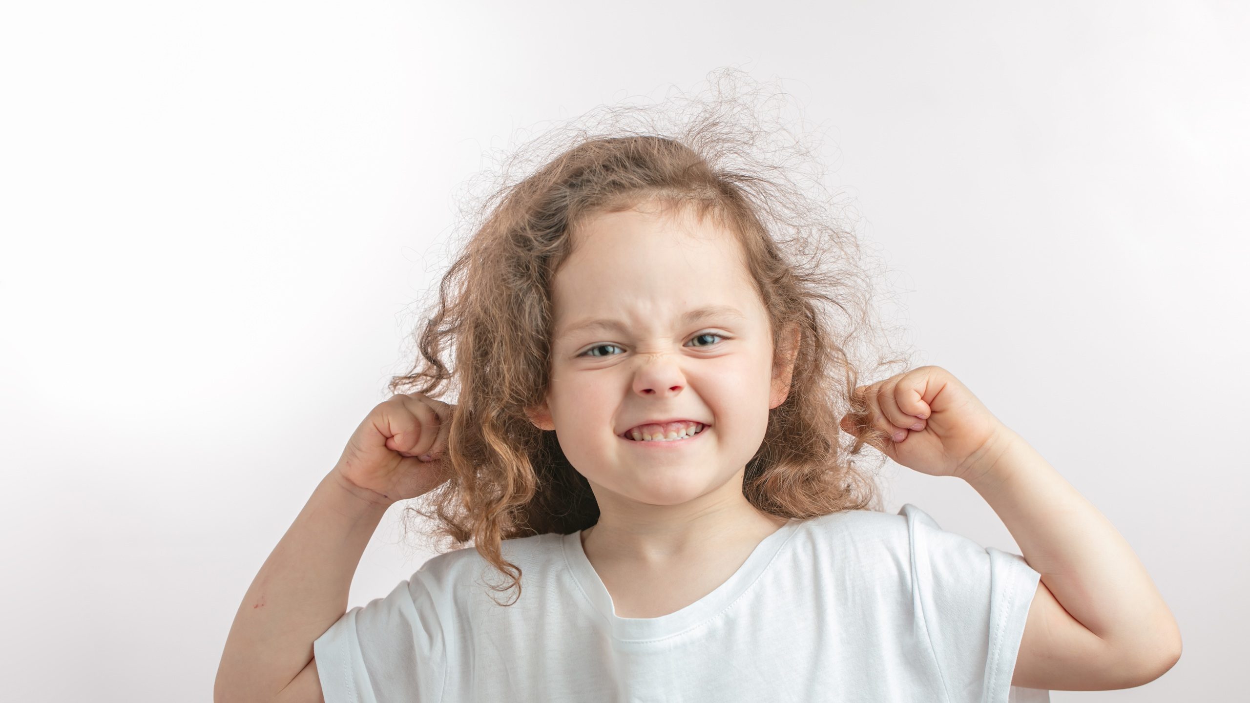 crazy awesome kid with clenched teeth showing her arm's muscles to the camera. health care,girl is boasting about her strength and power