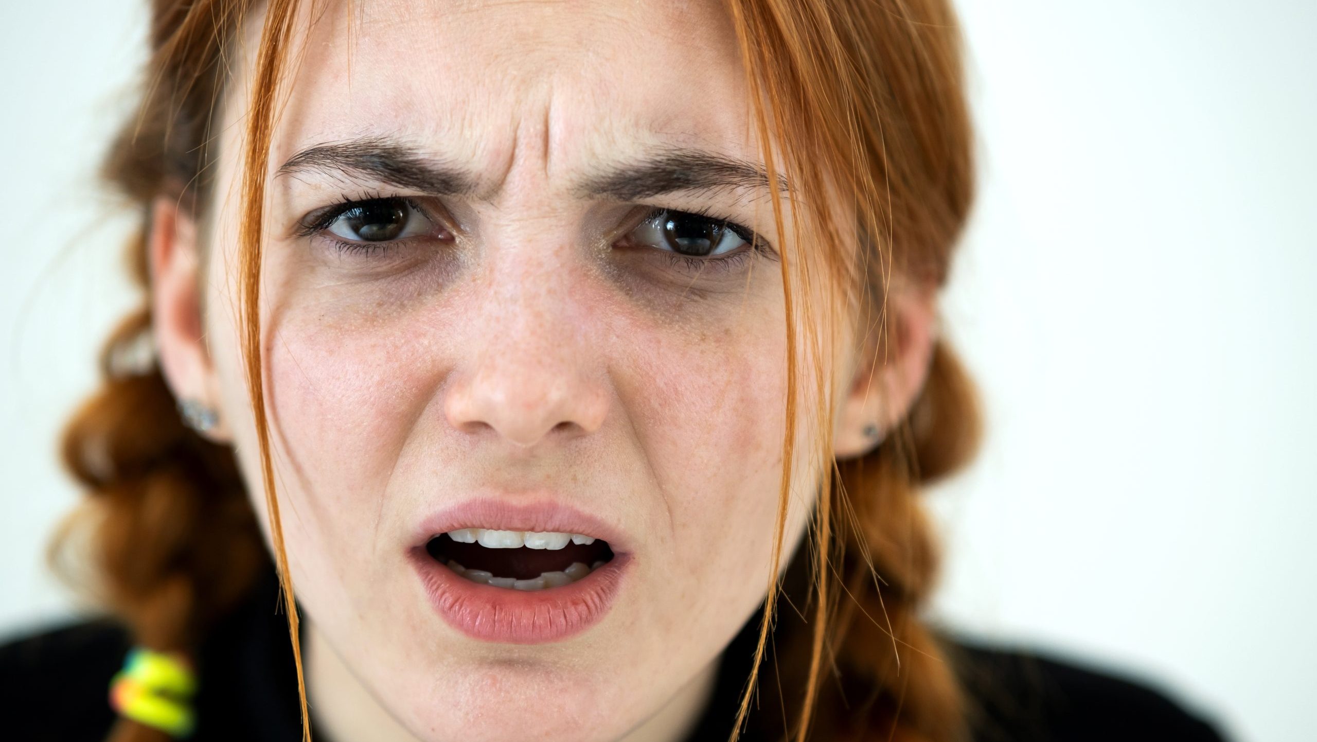 Close up portrait of angry redhead teenage girl.