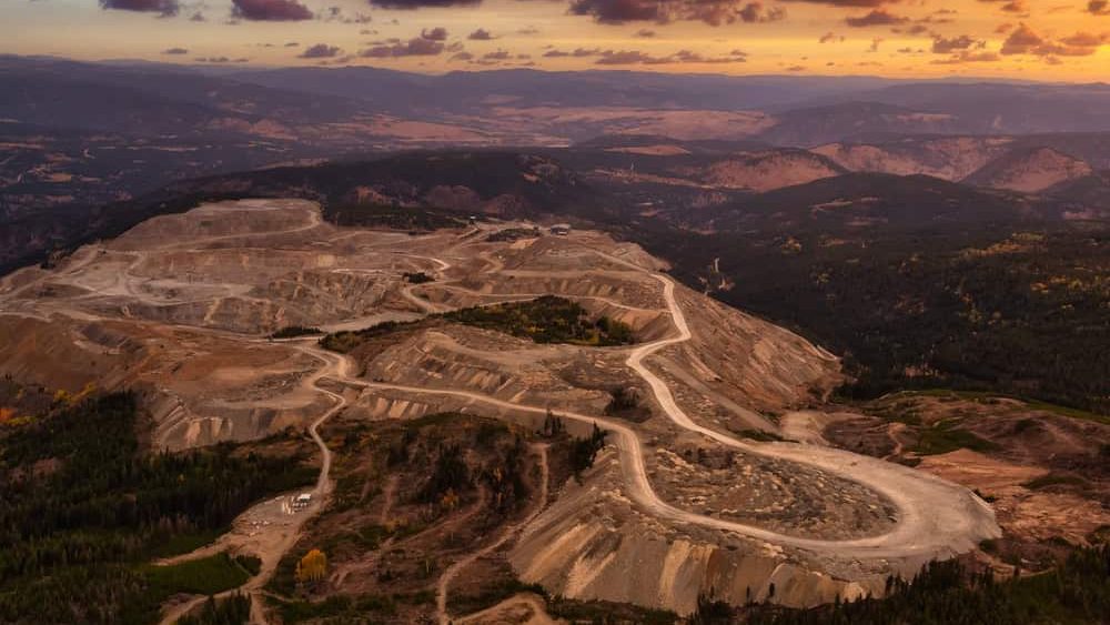 Aerial view from Airplane of a Mining Facility in the interior British Columbia, Canada. Sunset Sky.