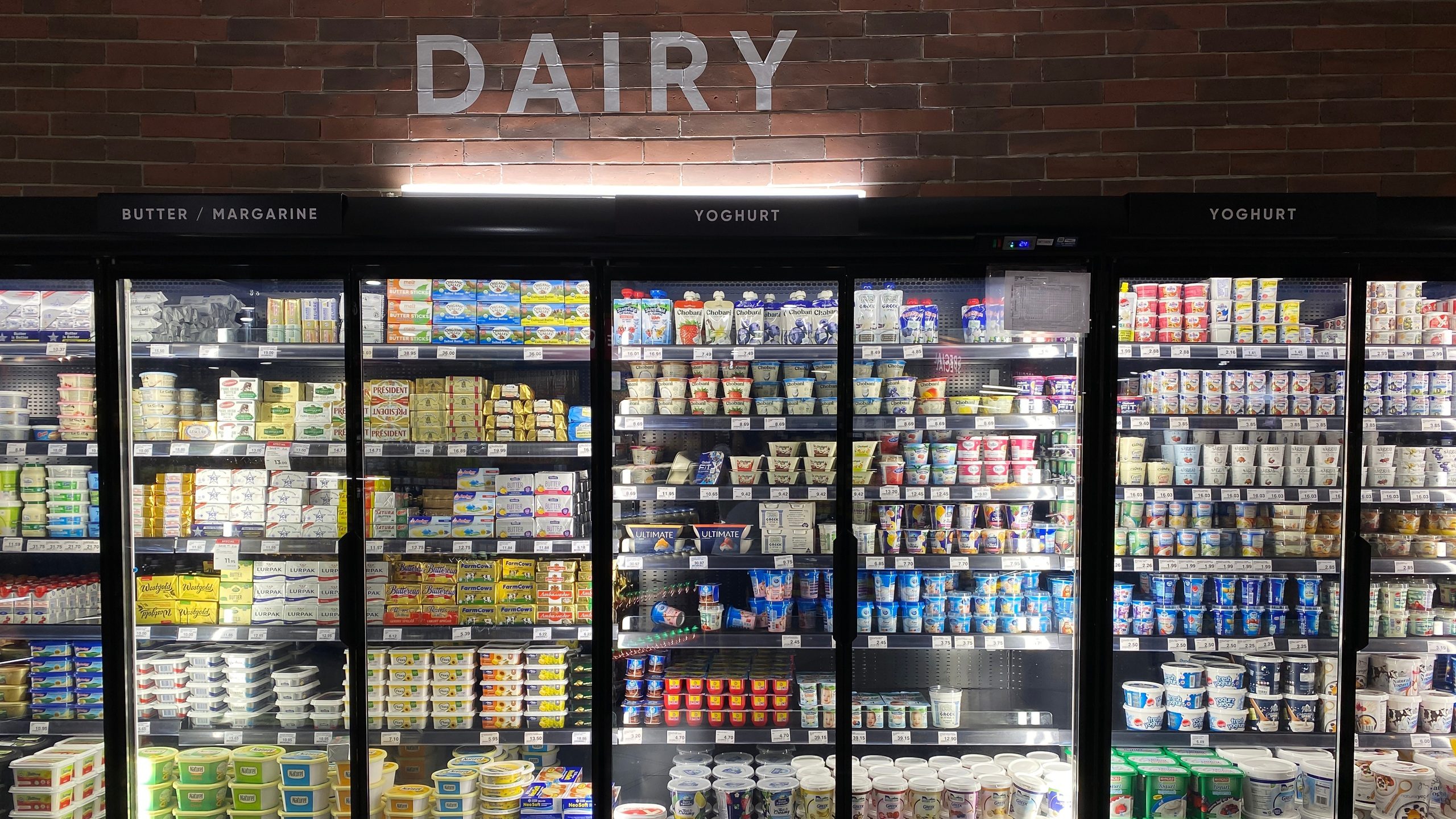 PENANG, MALAYSIA - NOV 16, 2021: Black grocery store fridge with dairy products.