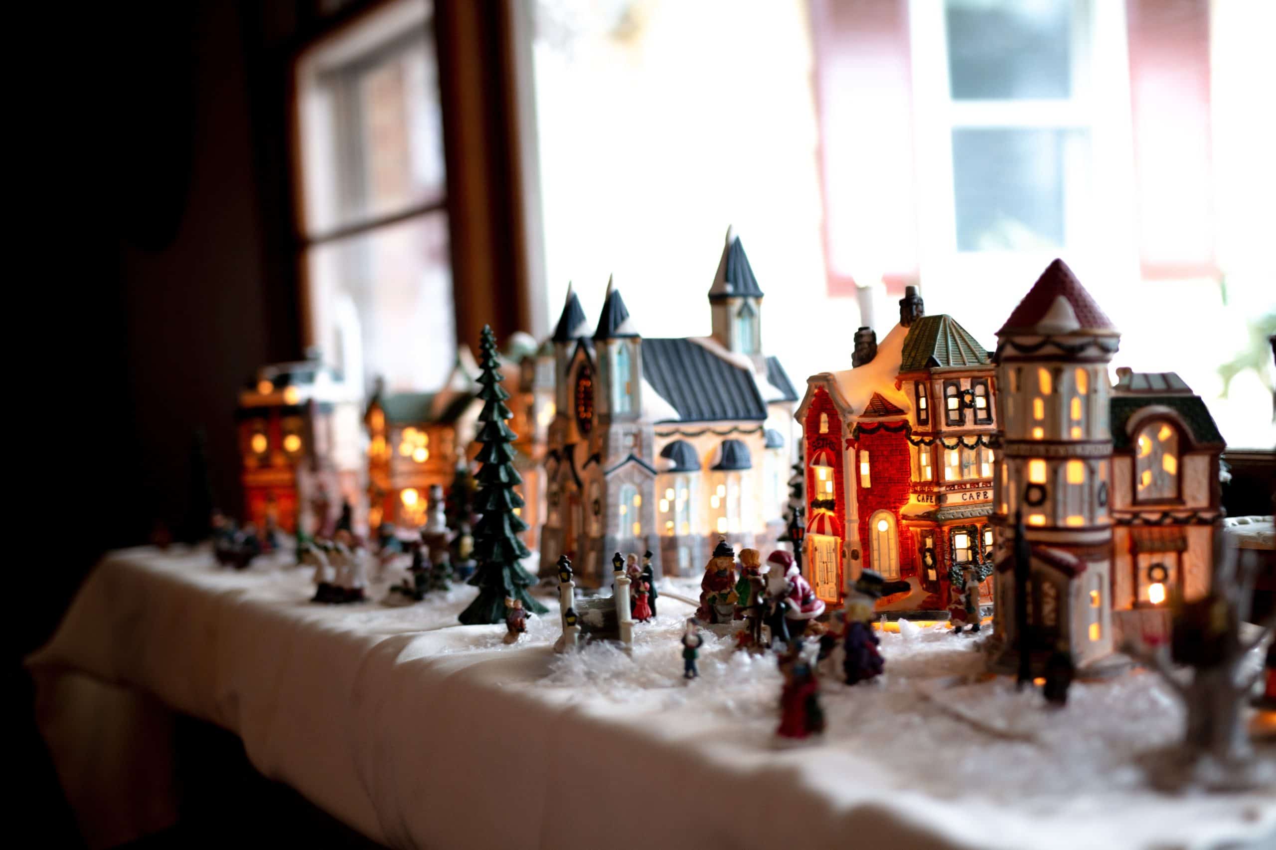 A close-up shot of a decorative mini Christmas village set on the table