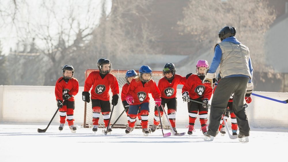 Coach guiding ice hockey team on rink