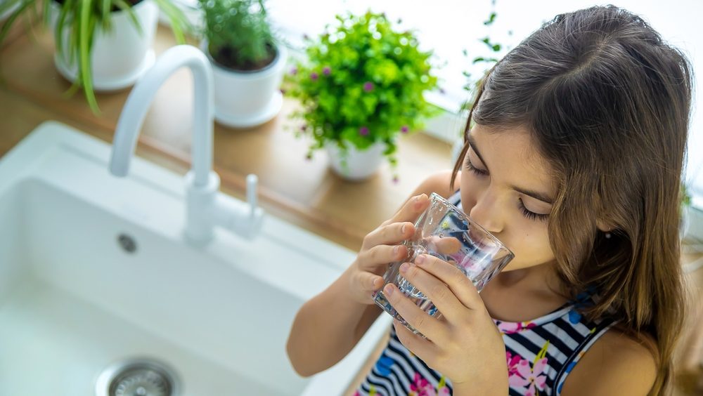 Children drink tap water at home. Selective focus.