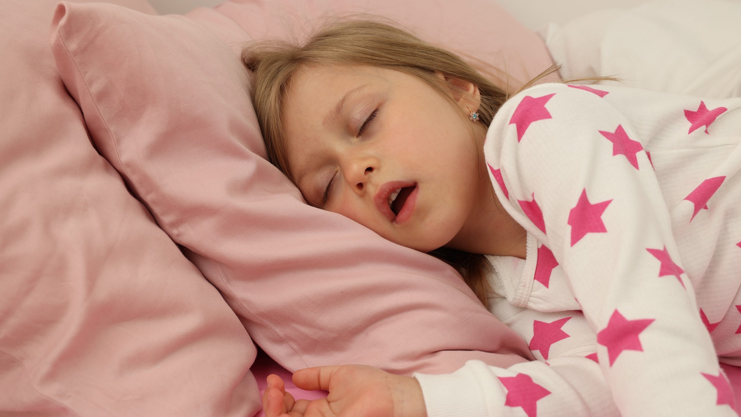 Little girl snoring while sleeping in bed