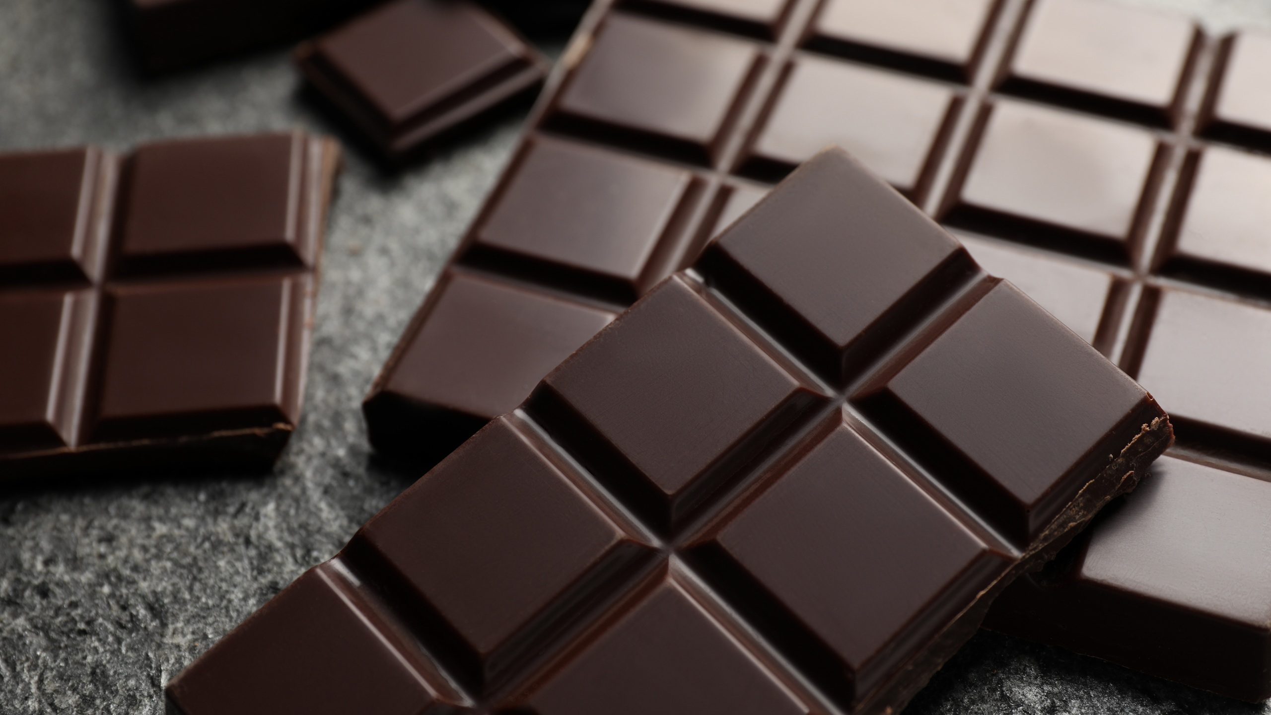 Delicious dark chocolate on grey table, closeup