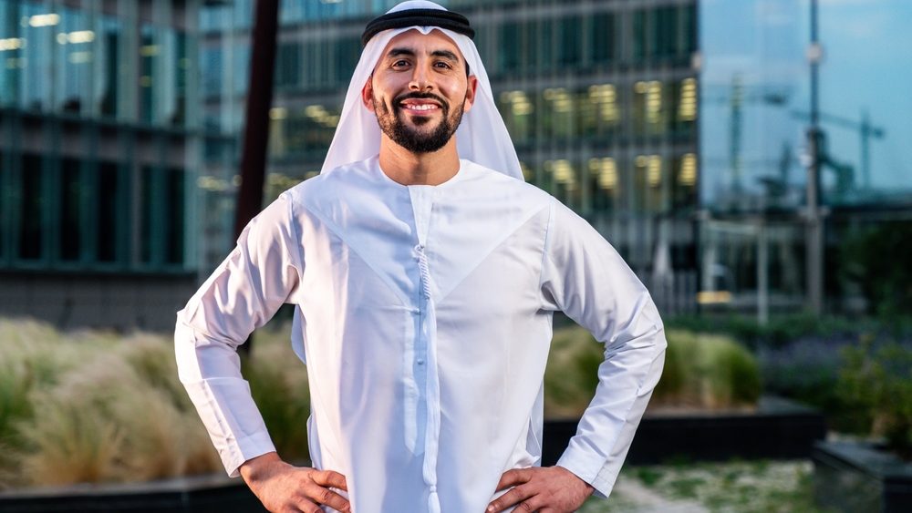 Arab middle-eastern man wearing emirati kandora traditional clothing in the city - Arabian muslim businessman strolling in urban business centre.