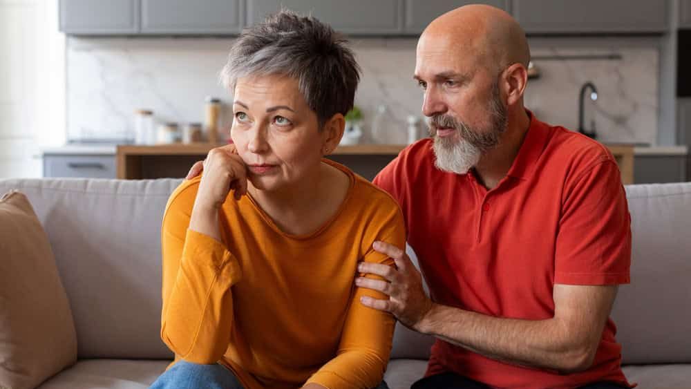Caring Senior Husband Comforting His Upset Offended Wife At Home, Worried Man Apologizing After Quarrel, Supporting Sad Souse, Mature Couple Suffering Relationship Crisis, Closeup Shot