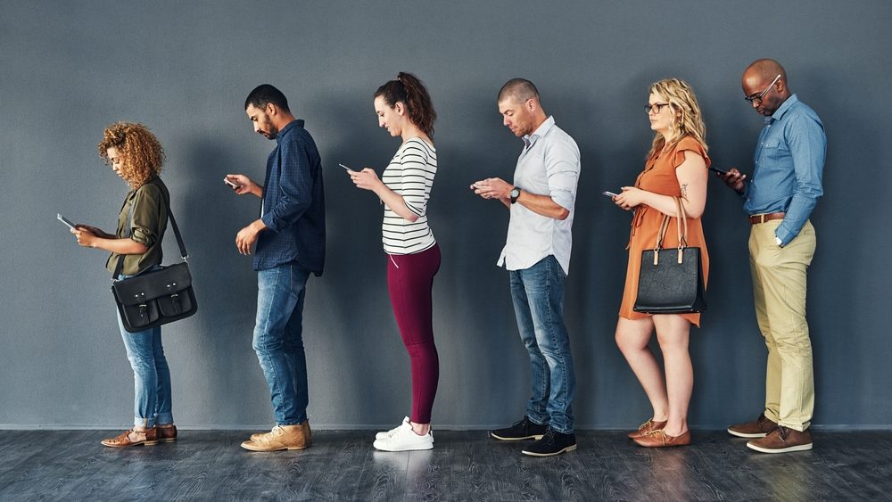 Businesspeople, job interview and waiting in line with technology or recruitment, onboarding or internet. Men, women and meeting diversity in queue or cellphone in office, human resources or hiring