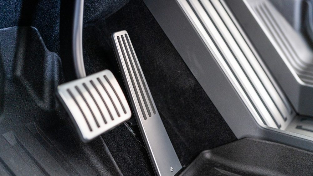Denver, Colorado, USA-May 5, 2024-This image features a close-up view of the aluminum accelerator and brake pedals alongside the metal floor mat in a Tesla Cybertruck, highlighting the vehicle sleek