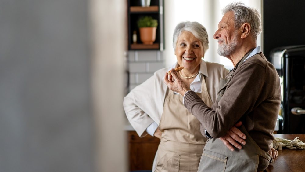 Happy senior couple communicating while having fun in the kitchen together