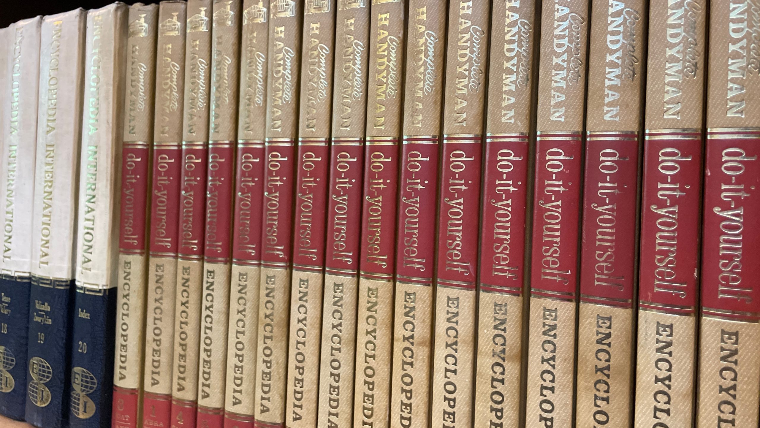 Yogyakarta, Indonesia - December 15 2024: A close-up view of a collection of vintage "Complete Handyman Encyclopedia" books with their spines lined up, showcasing the aged paper and gold lettering.