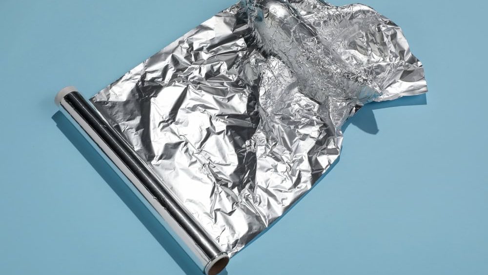 Roll of aluminum foil on blue background
