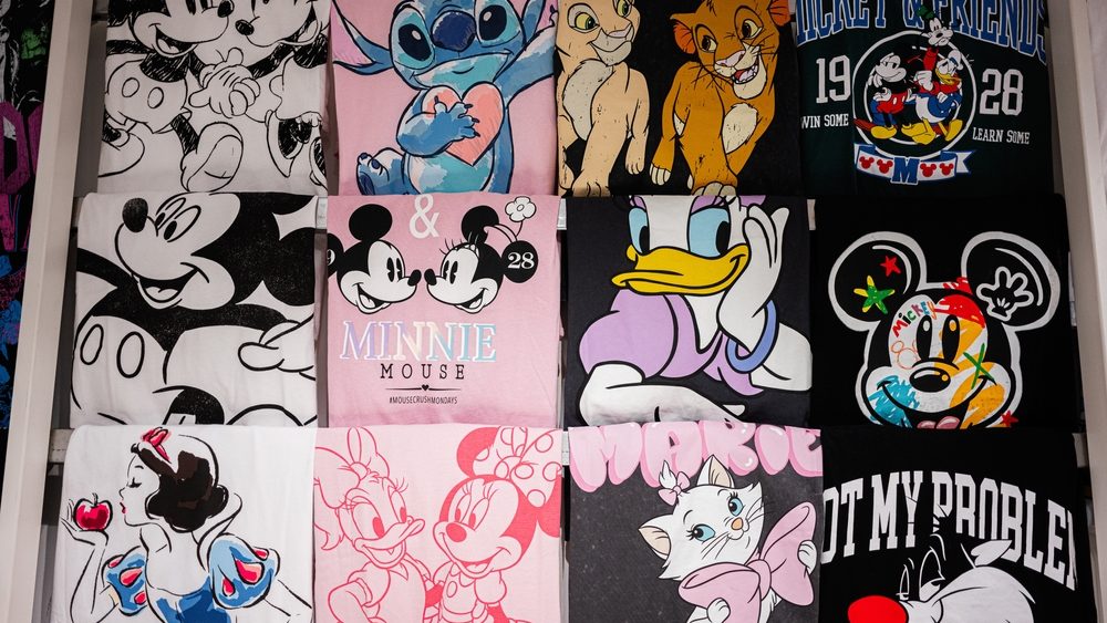 Assorted graphic t-shirts with beloved cartoon designs attractively arranged in a store display.
