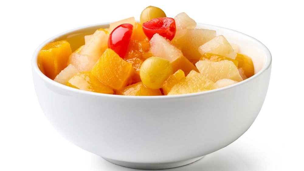 Bowl of canned fruit salad cocktail isolated on white background