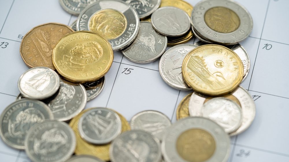 Pile of Canadian coins on calendar background. Toronto, Canada - September 18, 2025.