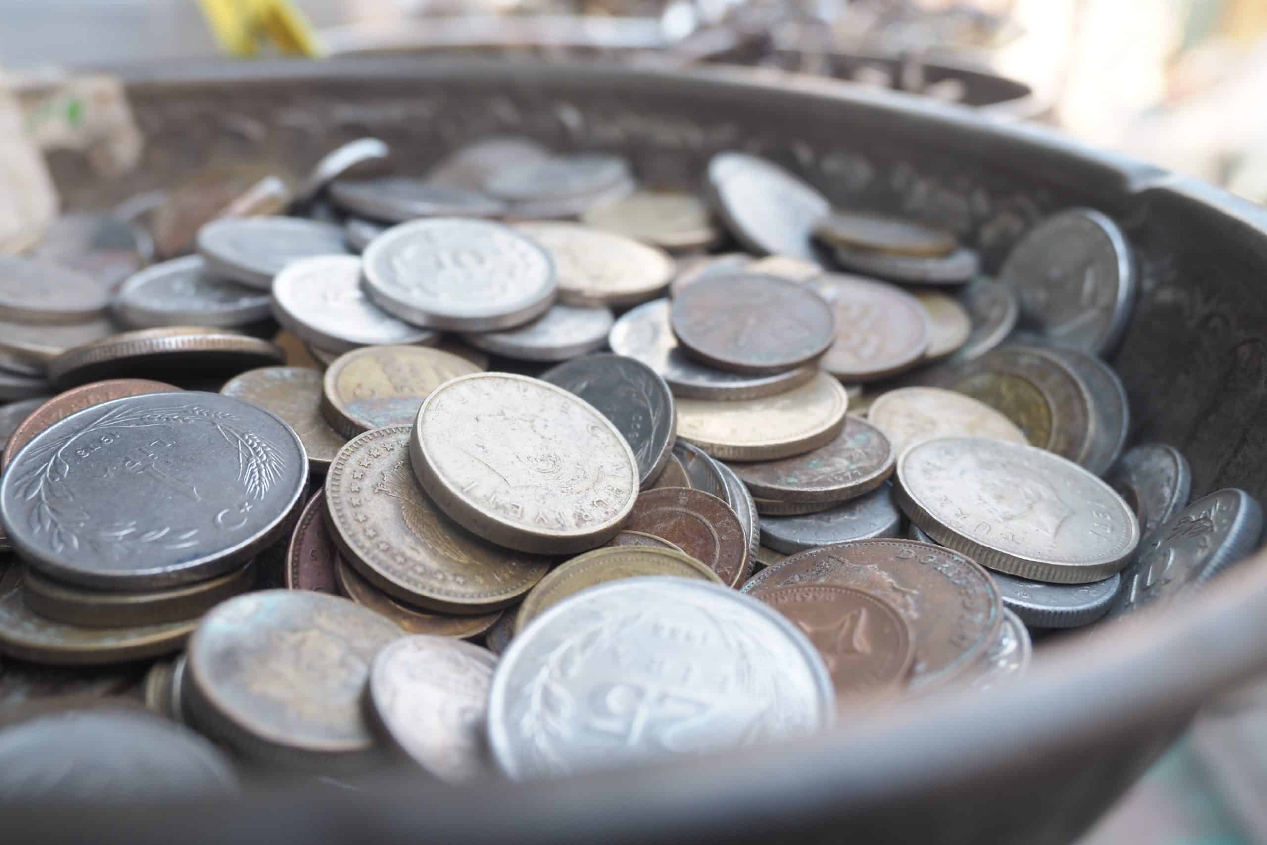 Coins collected in a vintage bowl at a market stall