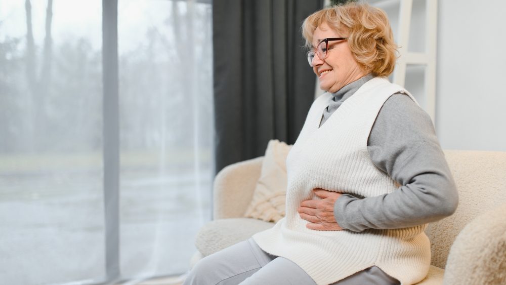 Elderly senior woman stomach ache illness, food poisoning in patient with bacterial infection. Unhappy old painful on stomach vomit and tired need medicine and rest.