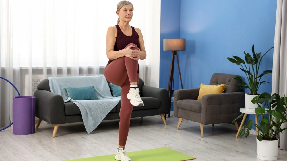 Senior woman exercising on mat at home, space for text. Fitness and sport