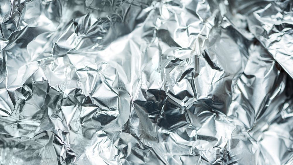 Abstract composition featuring a close up of crumpled aluminum foil with reflective highlights and deep shadows.