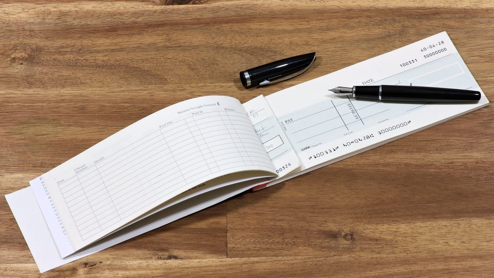 British checkbook on wooden desktop (account number is digitally altered and not real) 
