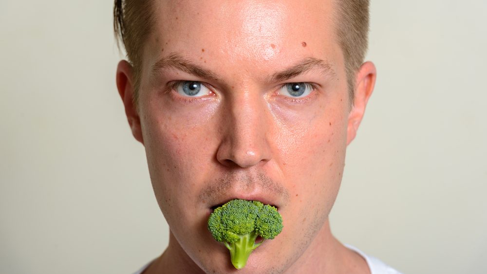Man eating broccoli