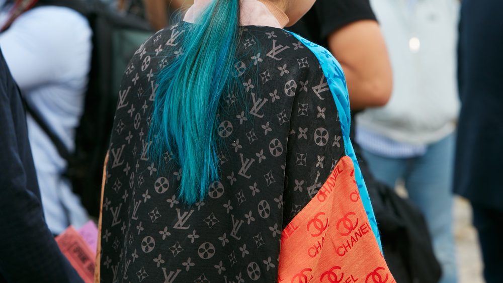 MILAN - SEPTEMBER 21: Woman with green hair and Chanel Louis Vuitton coat before Gucci fashion show, Milan Fashion Week street style on September 21, 2016 in Milan.