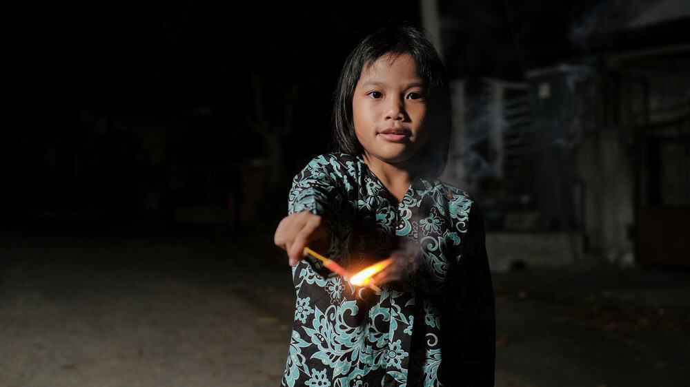 Malay girl celebrating Hari Raya Aidilfitri playing firework in hand